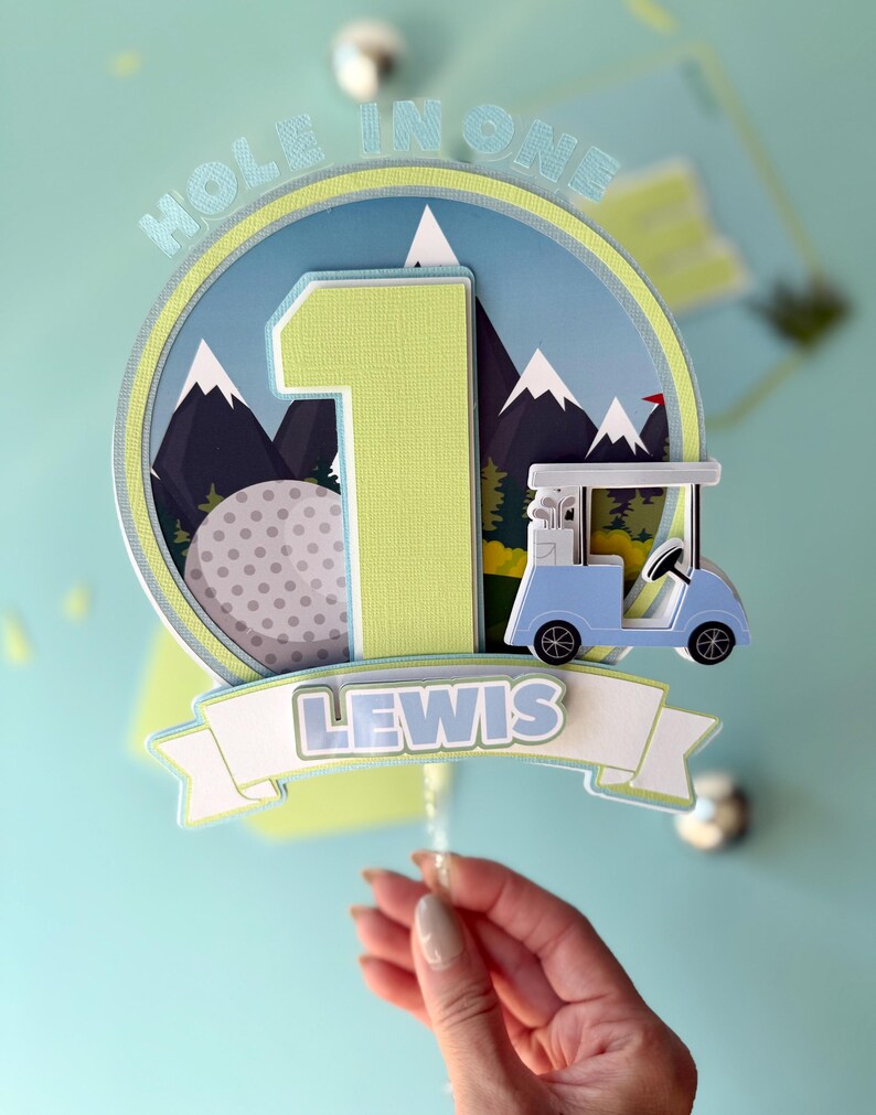 Green and blue golf birthday topper personalized for Lewis with Hole in One lettering