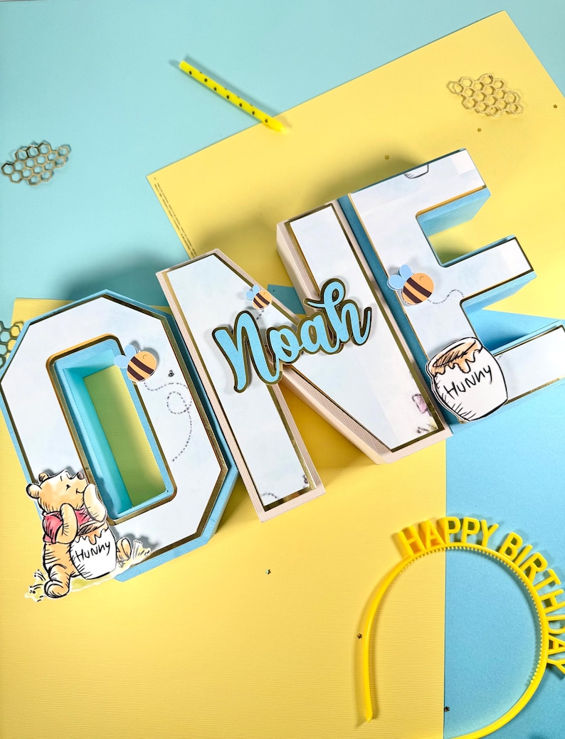Blue white and gold dimensional ONE letters personalized for Noah with a honey bear theme